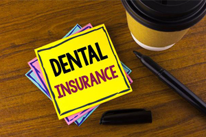 Dental insurance written on post card next to cup of coffee