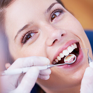 Lady in dental chair smiling at dentist