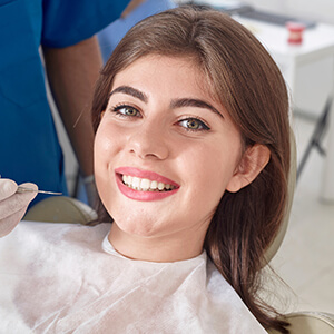 Young lady relaxing on dental chair smiling