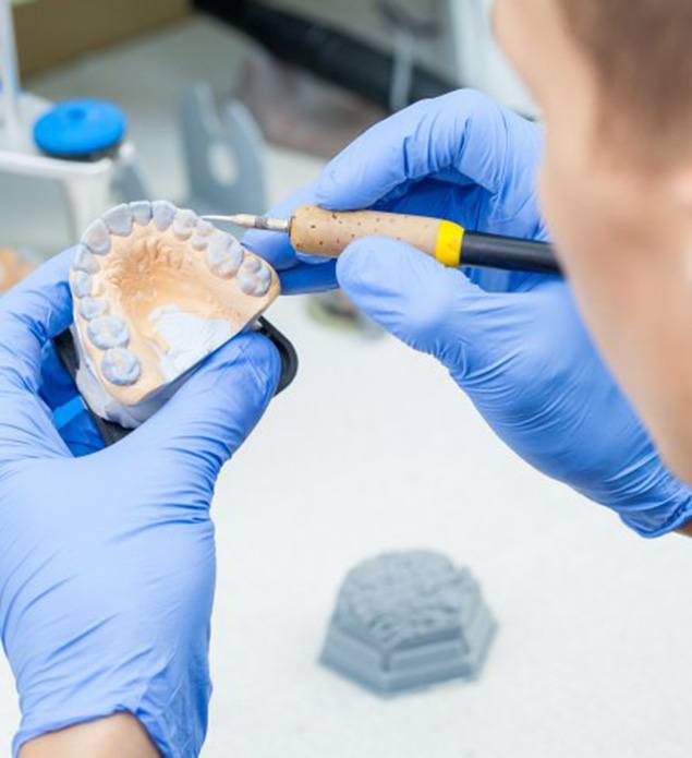 Lab technician creating a denture mold