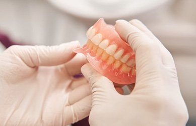 Lab technician examining dentures