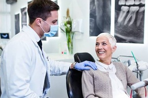 Woman in dental chair smiling at dentist