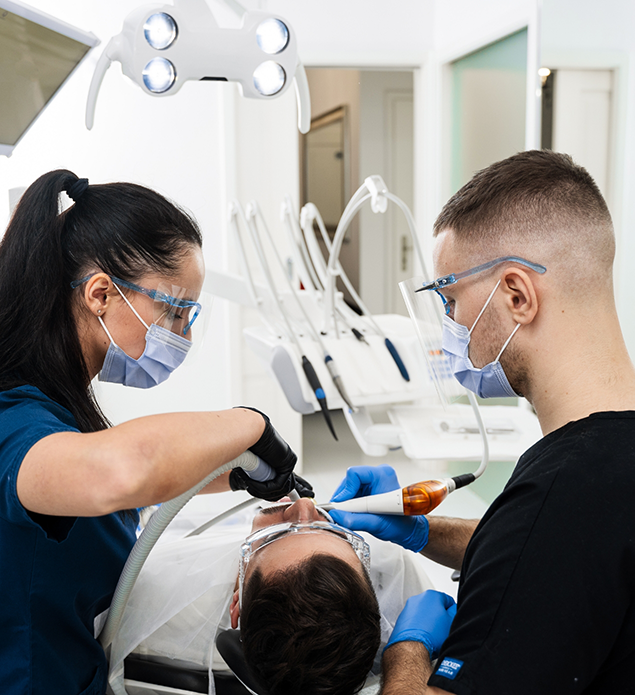Dentist and assistant examining a patient's mouth