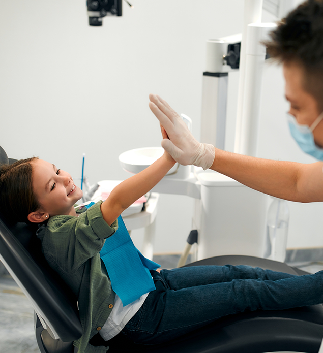 Young girl giving a high five to her dentist