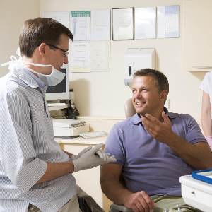 Smiling man talking to dentist