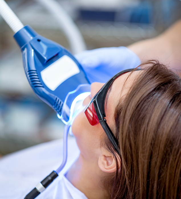 Woman in the dental chair getting professional teeth whitening