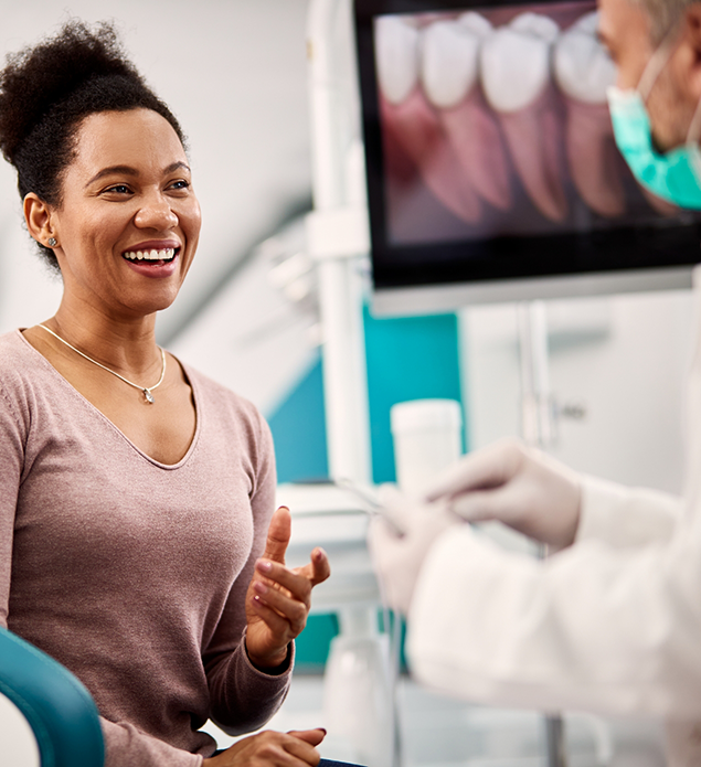 Woman grinning while talking with her dentist