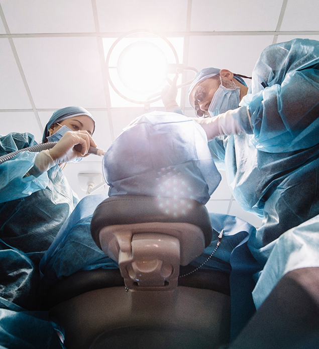 Dentist and assistant performing a dental implant procedure on a patient
