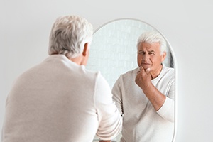 Patient in Sparks checking their dentures in the mirror
