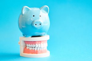 A blue piggy bank sitting on top of a denture model