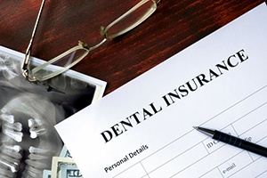 Dental insurance form sitting on a wood desk