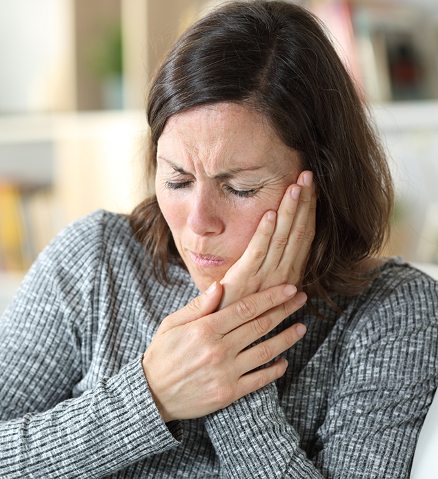 Woman holding the side of her face in pain