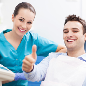 Smiling man in dental chair giving thumbs up