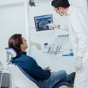 Dentist and patient looking at digital dental x-rays