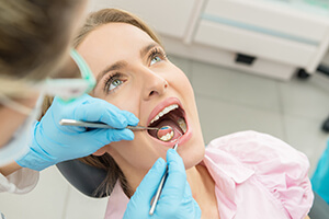 lady undergoing oral examination by dentist