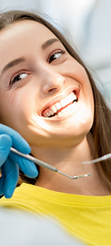 Woman in the dental chair smiling at her dentist
