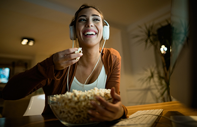 Woman eating popcorn while watching TV