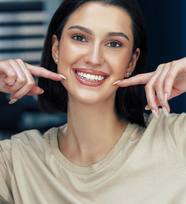 Smiling brunette woman pointing to her flawless teeth