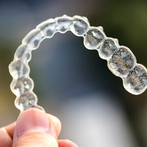 someone holding clear aligner