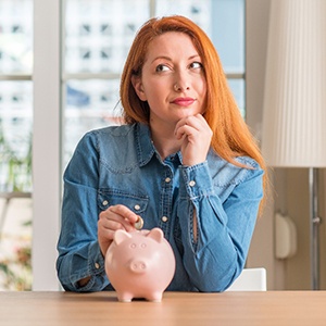 Woman putting a coin in a piggy bank