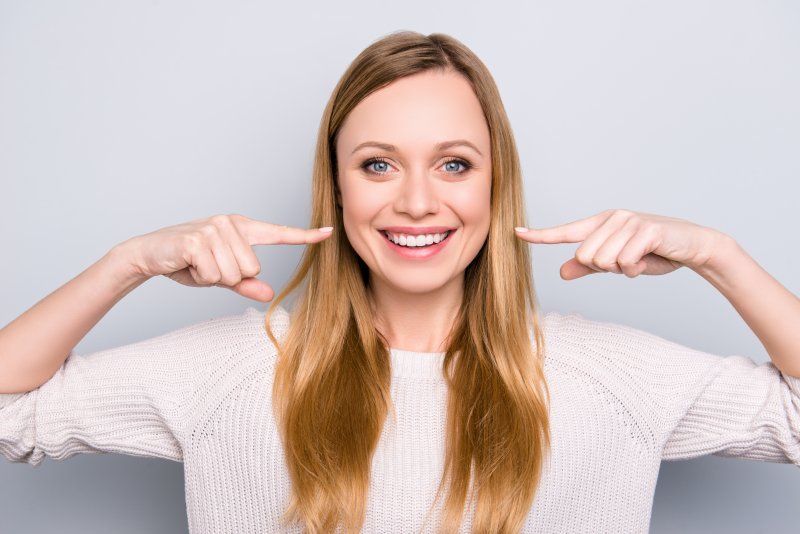 Woman pointing to her white smile
