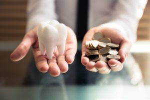 tooth in one hand and coins in the other 