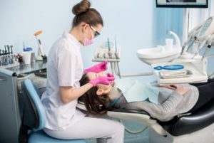 Dental hygienist cleaning a patient’s mouth