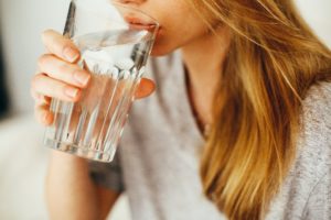 Woman with a glass showing water quality.