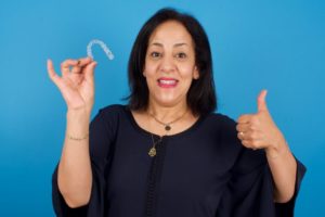 Mature woman giving thumbs up for clear aligners for seniors