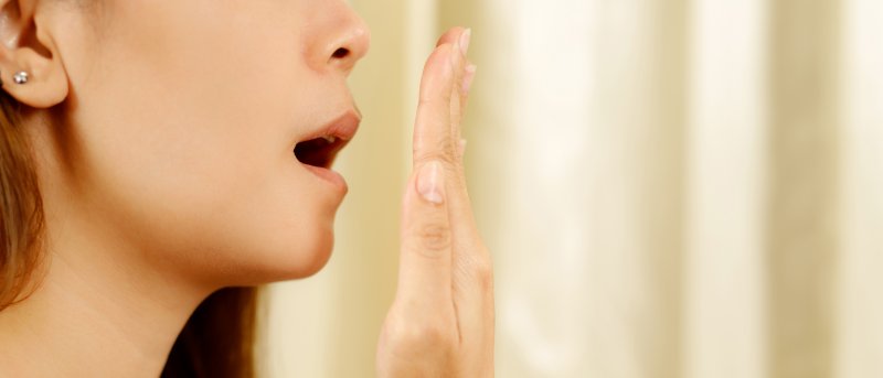 woman checking to see if she has bad breath in Sparks