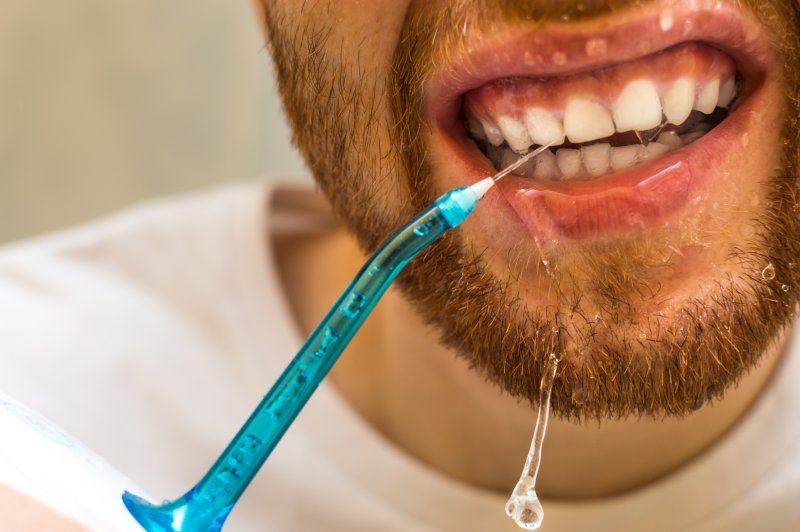 man using a Waterpik in Sparks