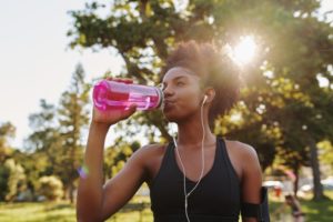 woman drinking water after workout 