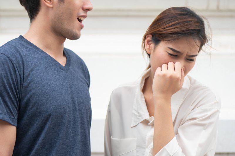 A woman smelling a man’s coffee breath