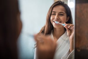 a woman brushing her teeth during the spring 