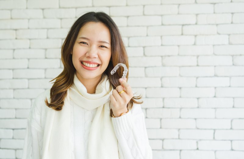 Young woman holding her clear aligners