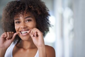 Woman flossing her teeth.