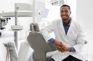 Dentist sitting and smiling for camera.